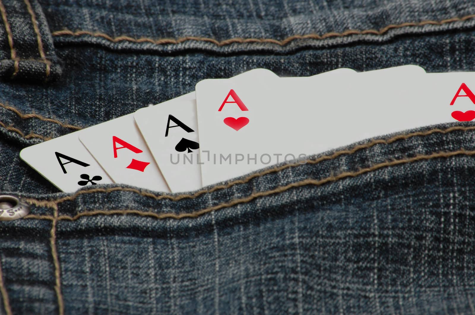 four playing cards in the pocket of a pair of jeans