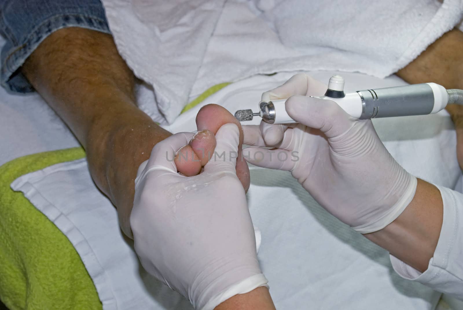 A pedicure removing hard skin from a client's feet