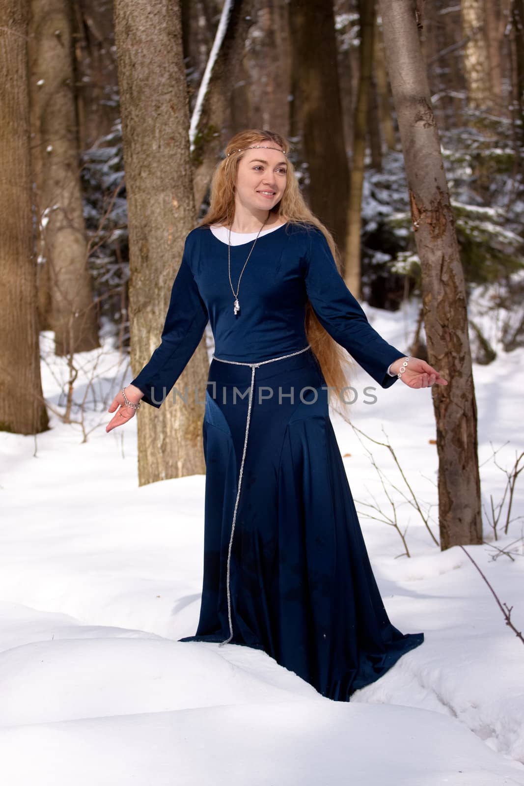 Lady in blue dress and tree trunks
