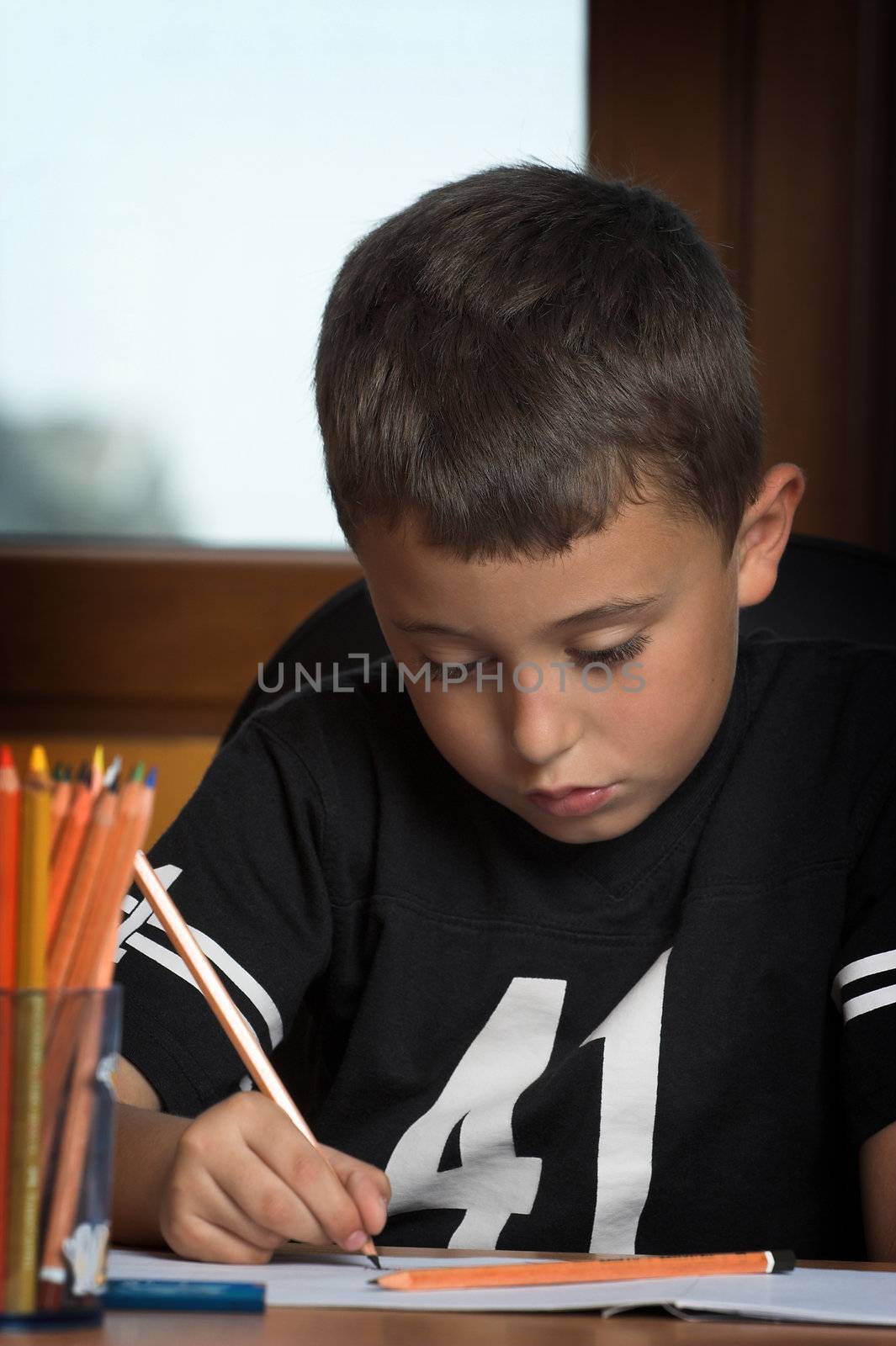 A young schoolboy write his  homework
