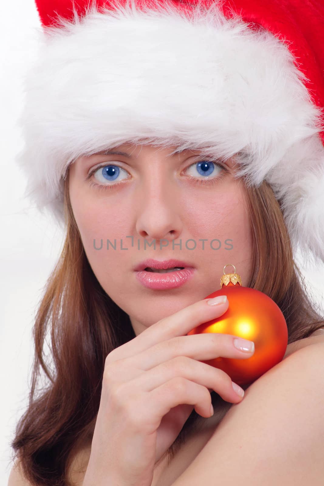 Portrait of the nice girl in a red cap and with a New Year's toy removed close up