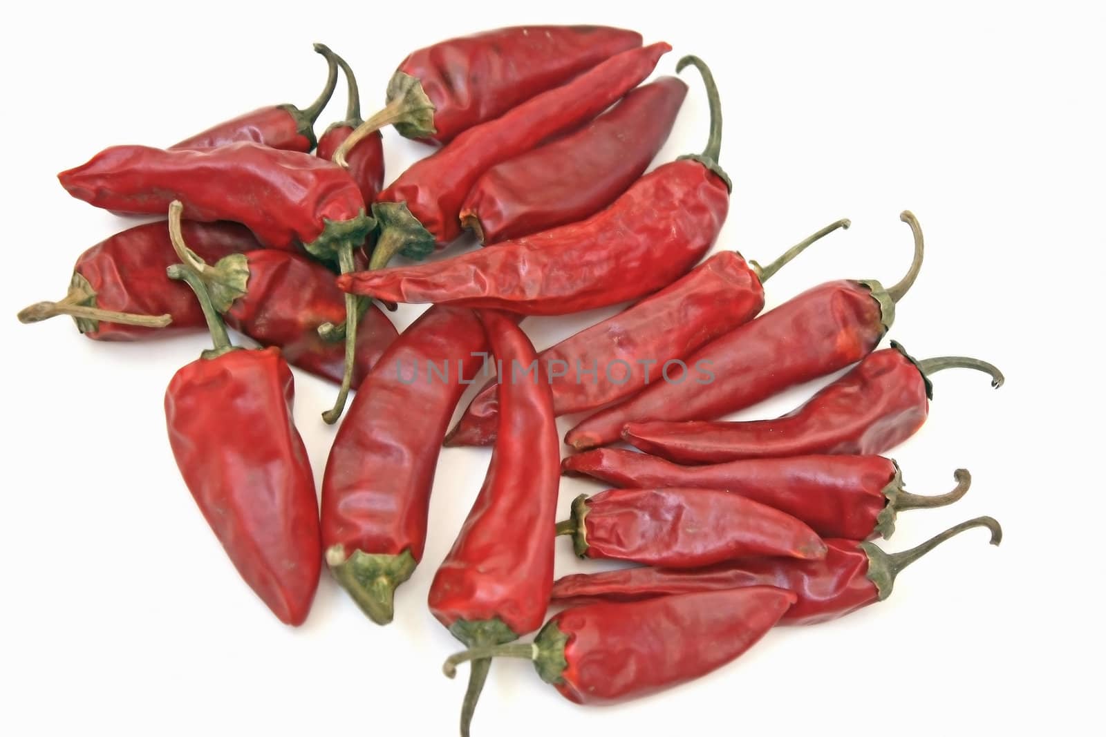 Heap of brilliant red bitter pepper on a white background.