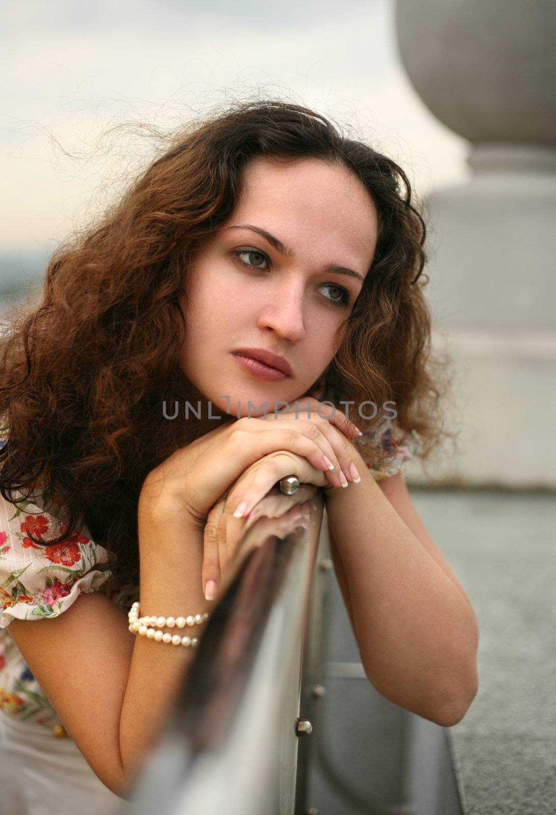 Portrait of the thoughtful girl on a roof of a house