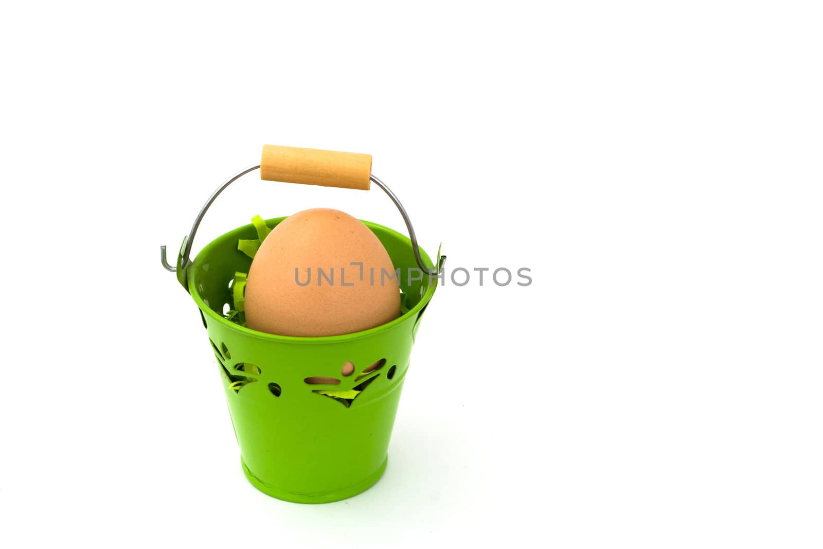 Uncolored egg in green basket, on white background.