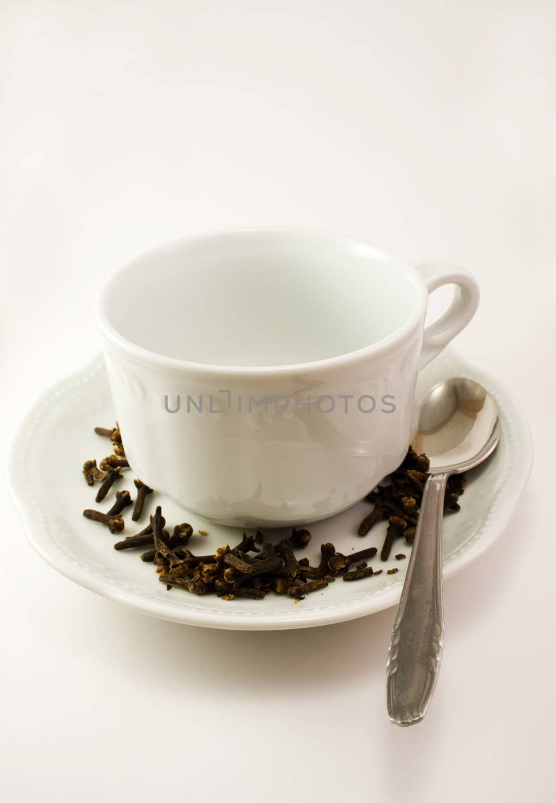 Empty cup for tea with spoon, saucer and decoration.