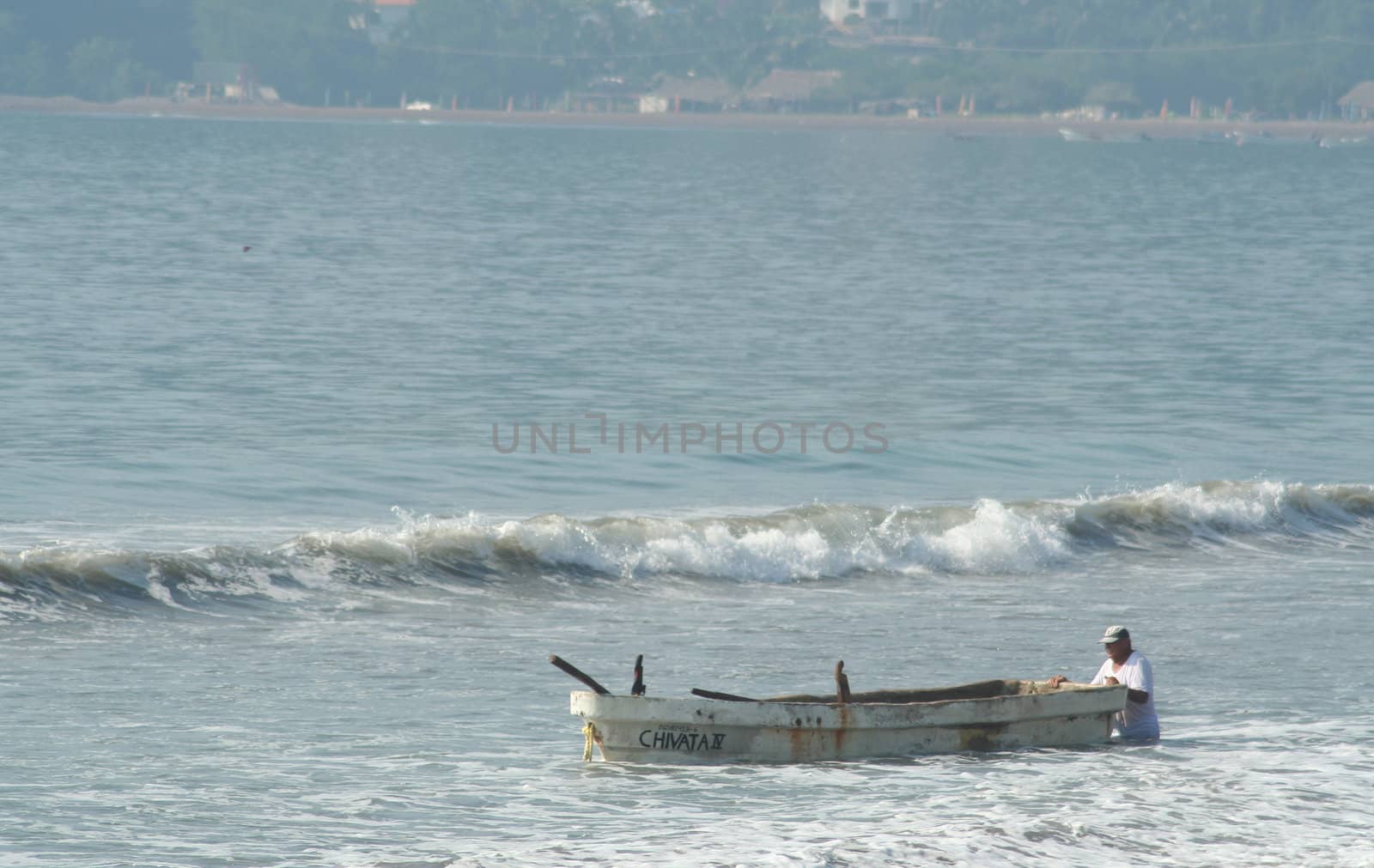 Fishermen with his boat fighting the waves