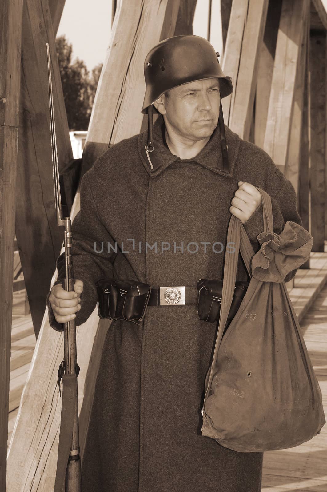 Old style picture with man in soldier uniform with weapon. Costume is authentic to the ones weared in time of  World War I.