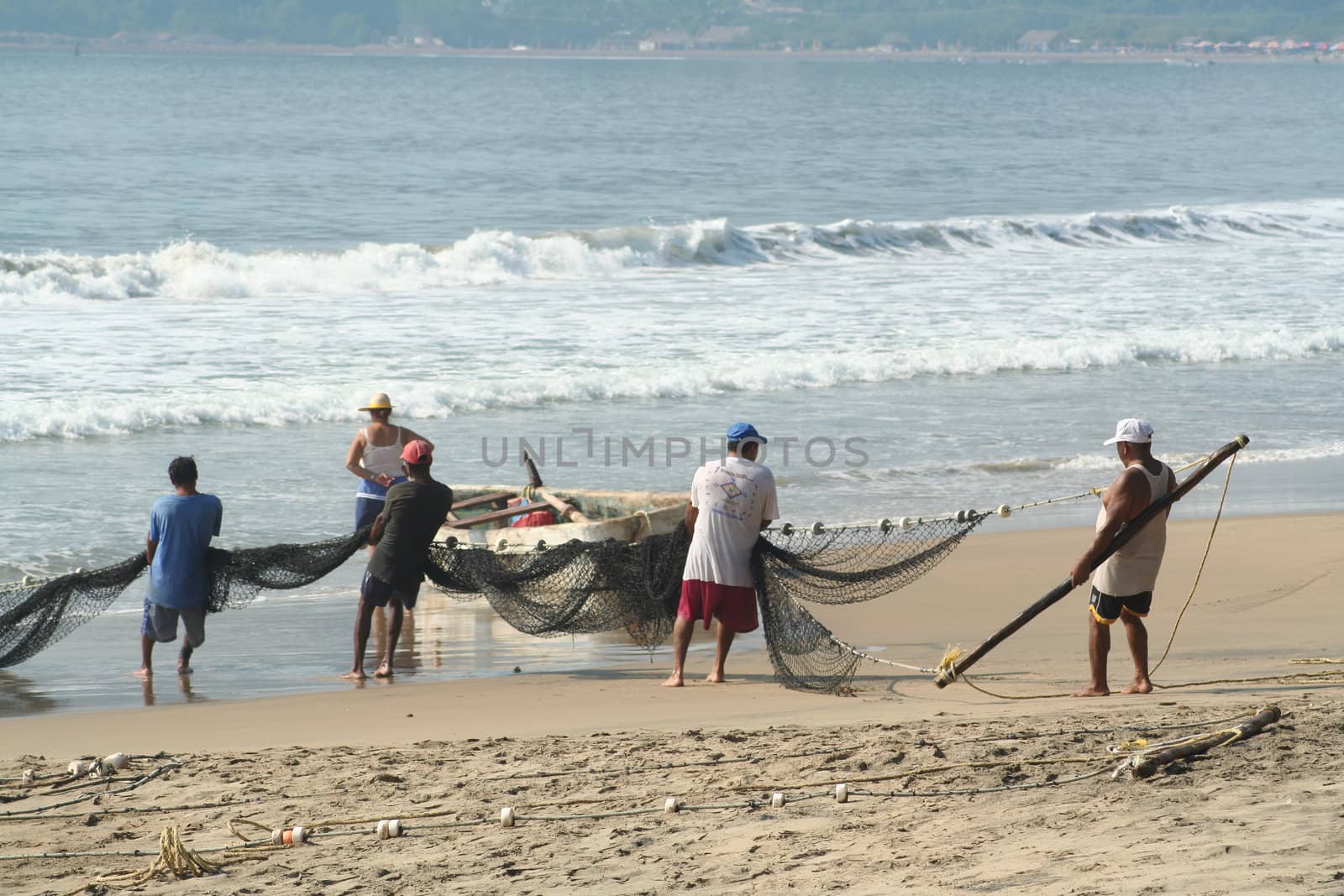 Fishermen pulling in net from the beach