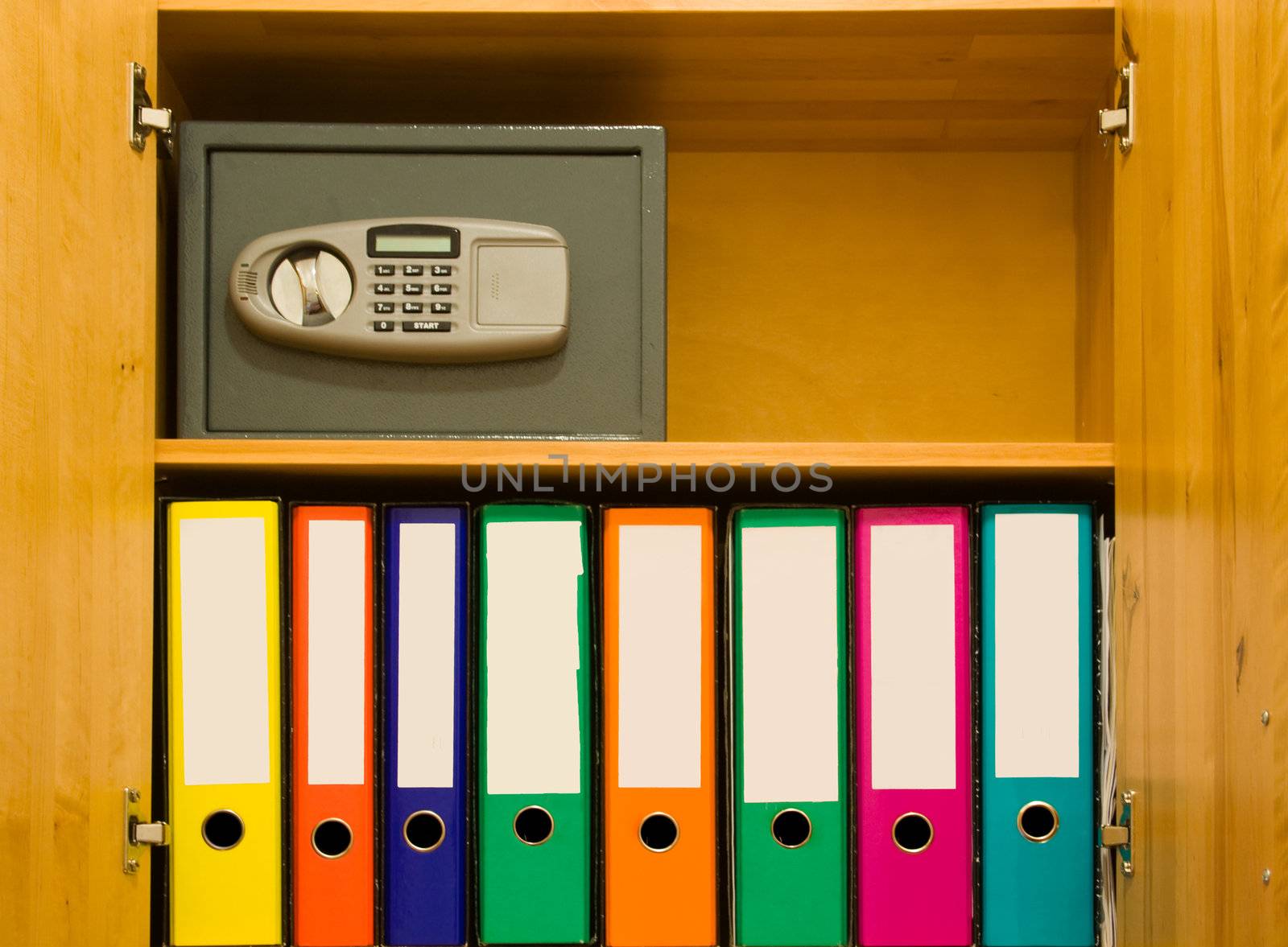 Different coloured files with blank labels and safe in a closet.