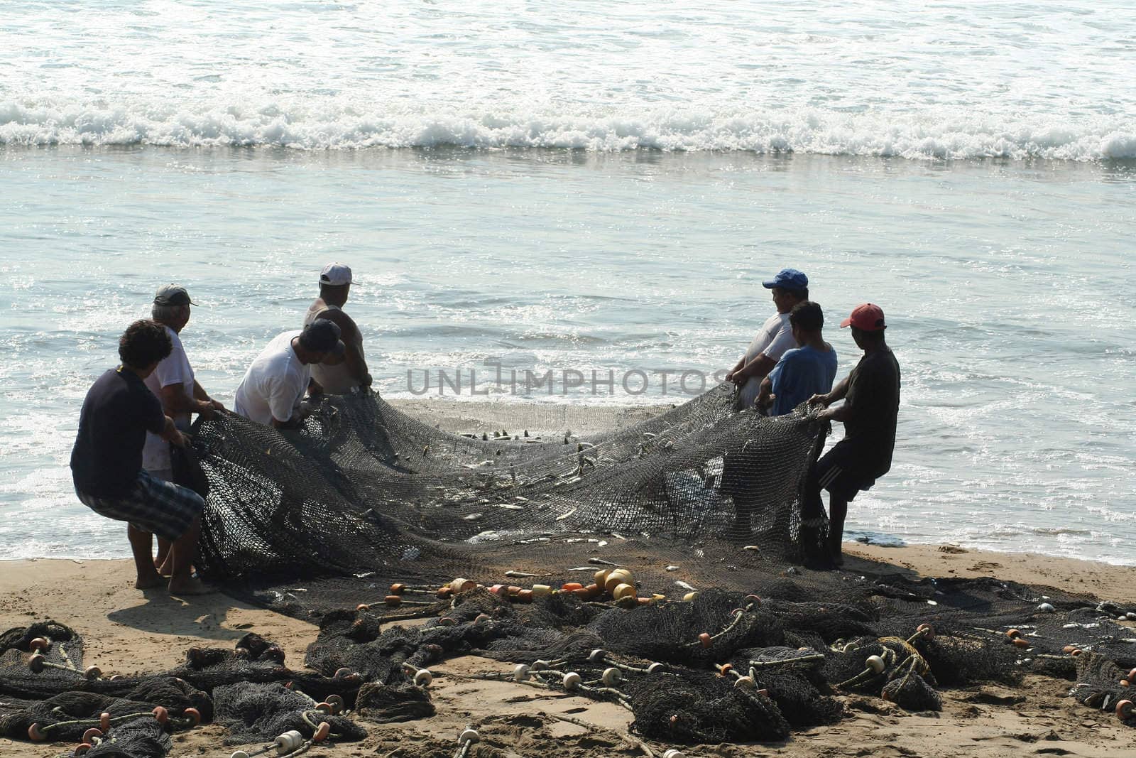 Fishermen pulling in net from the beach