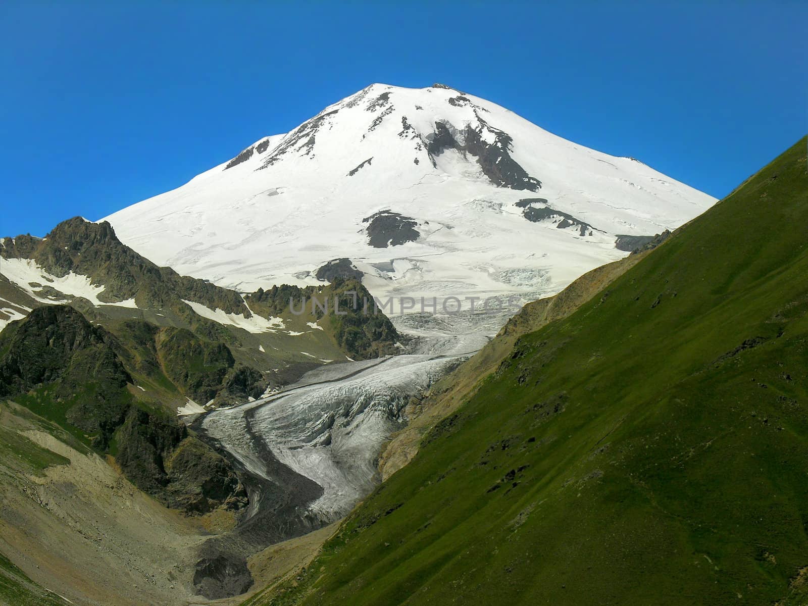  Snow-covered top of mountain on a background of the blue sky
         