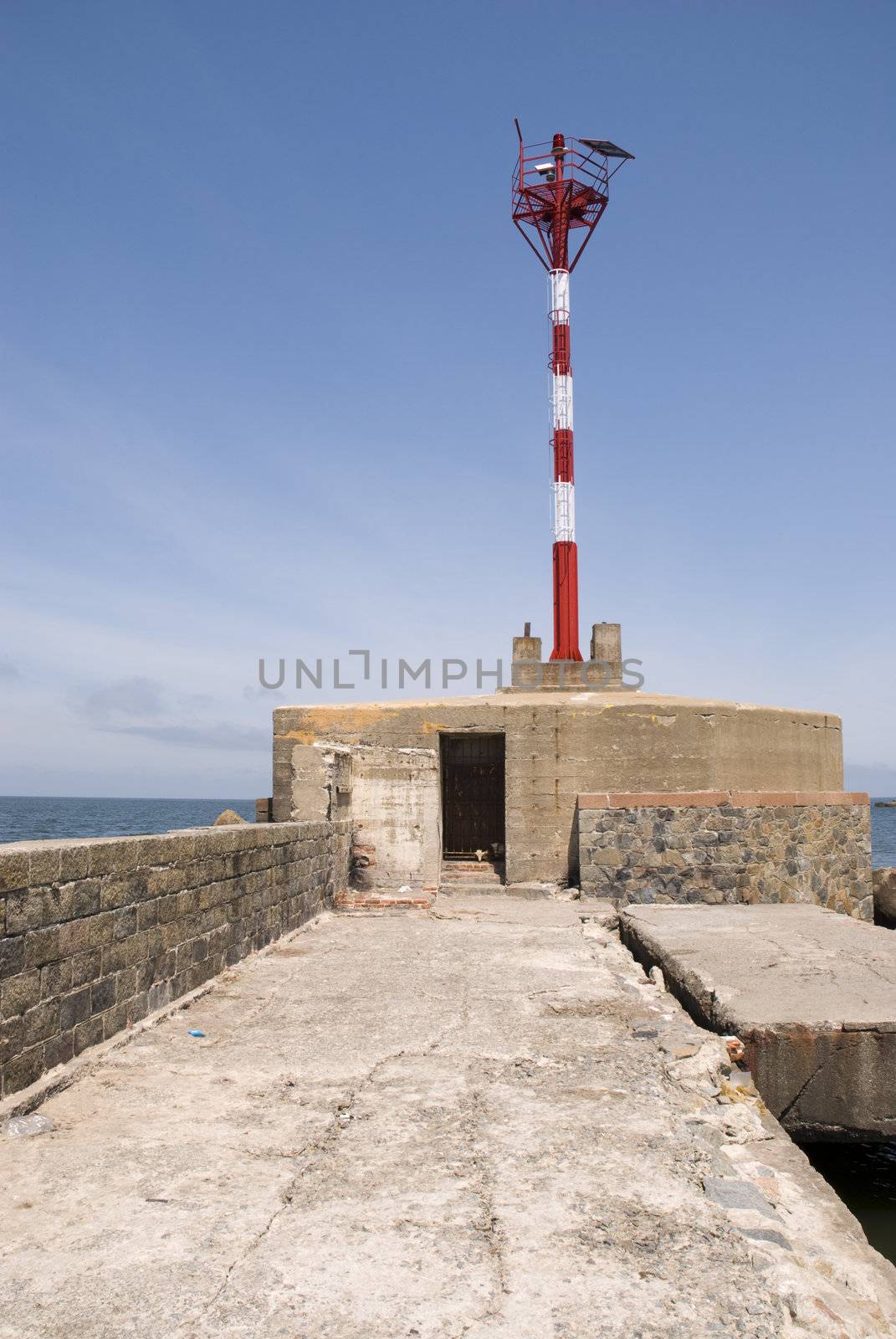 Perspective shot of pier in Montevideo, with small lighthouse in its end