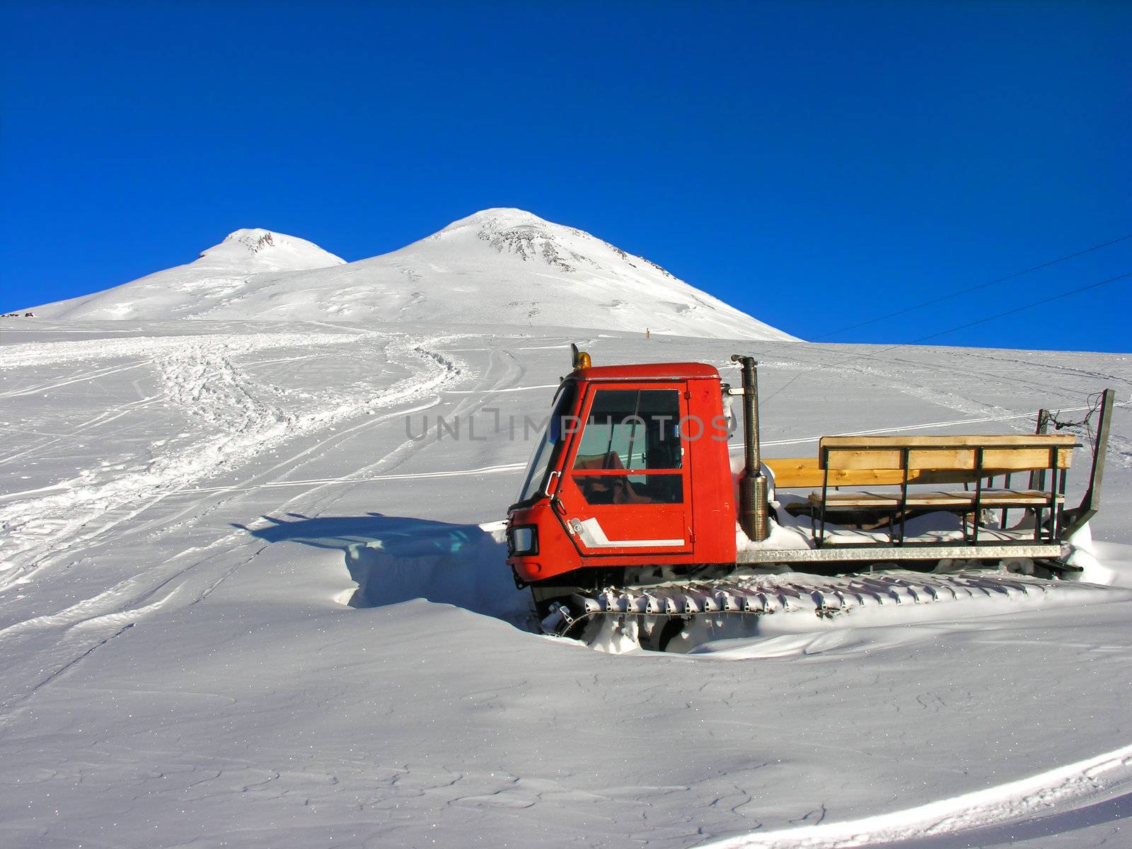 The red snowmobile  frozen in a snow.
          