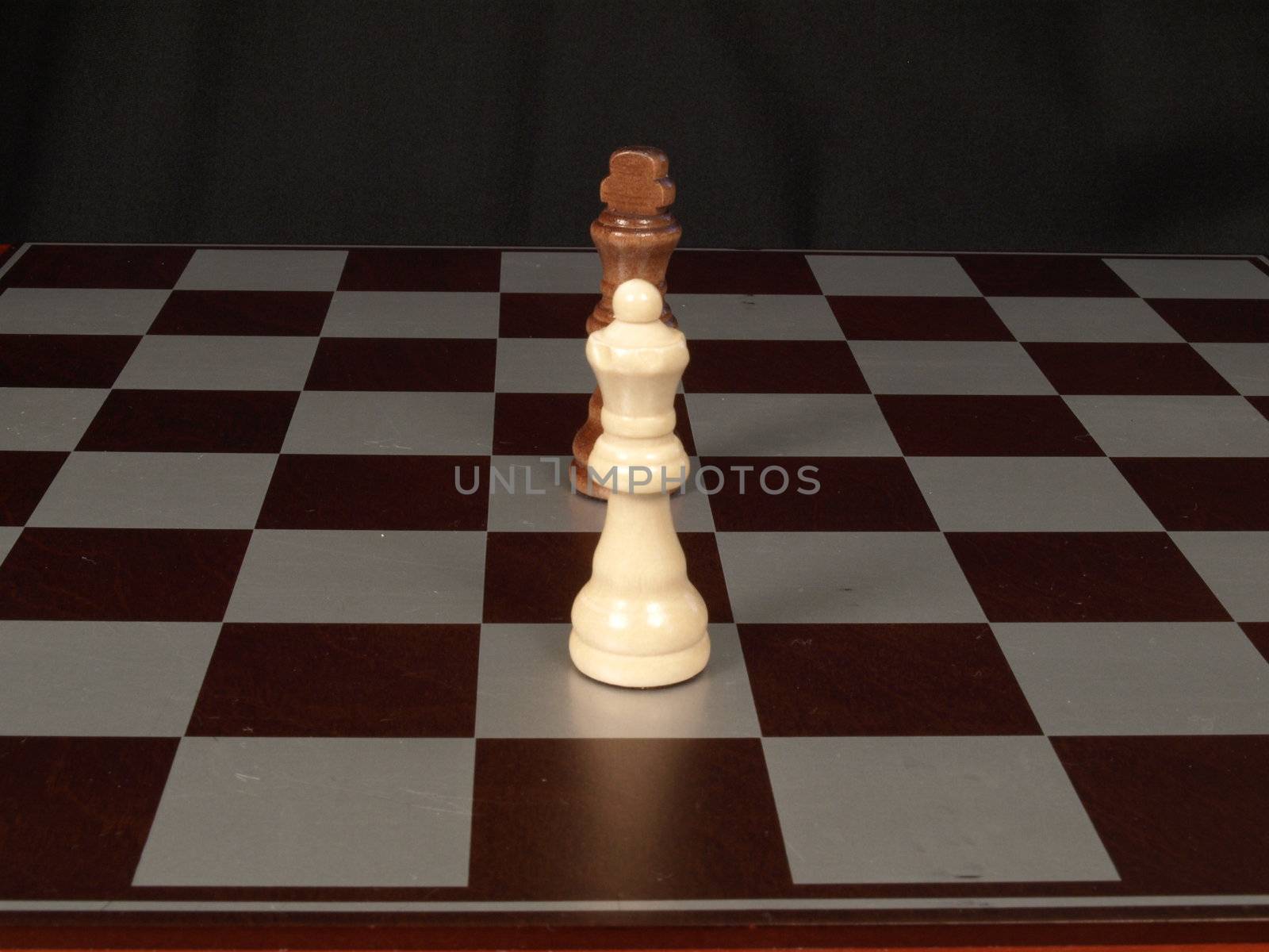 White king, black queen on a chess board