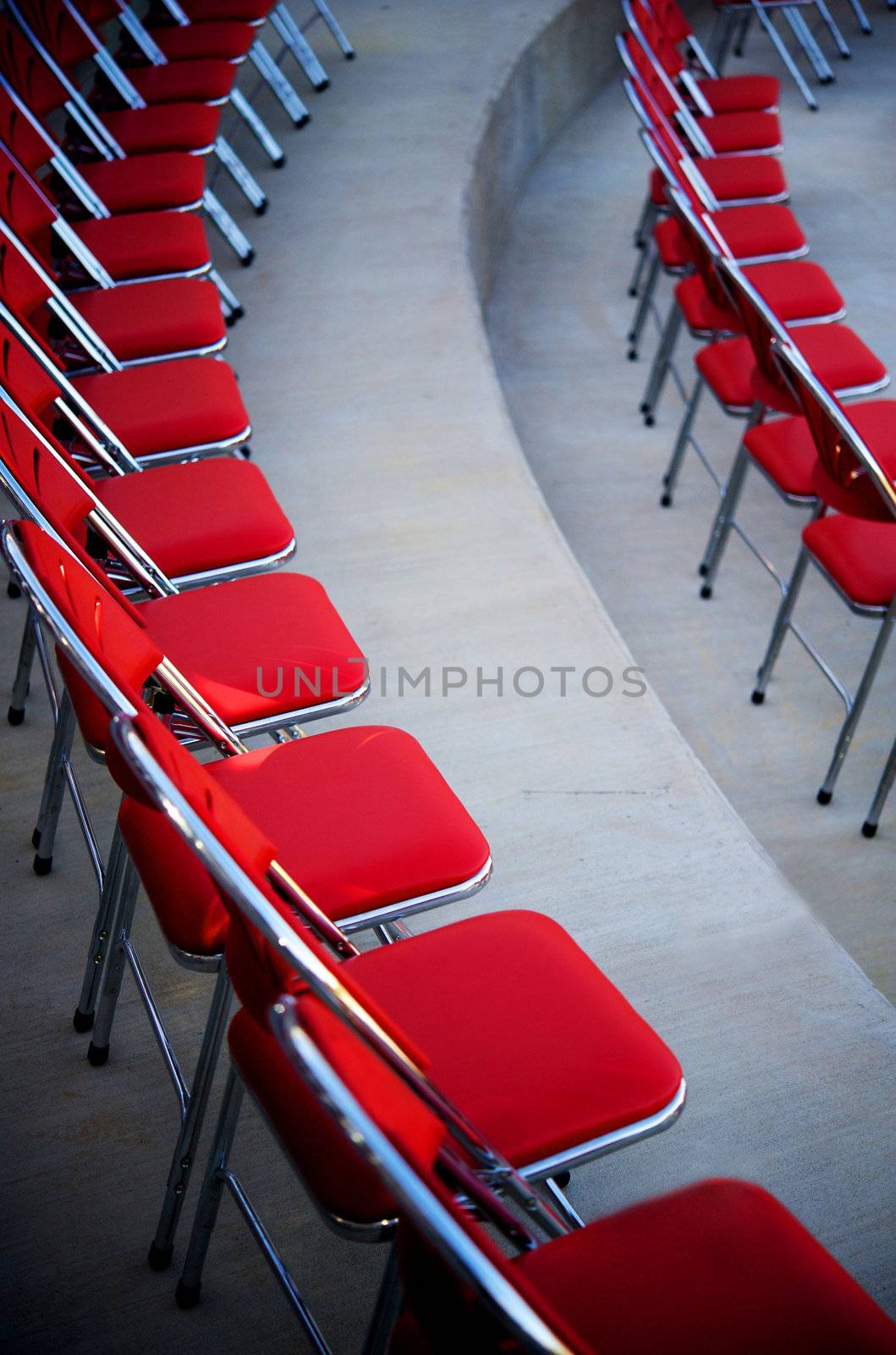 An image of a curved rows of red chairs