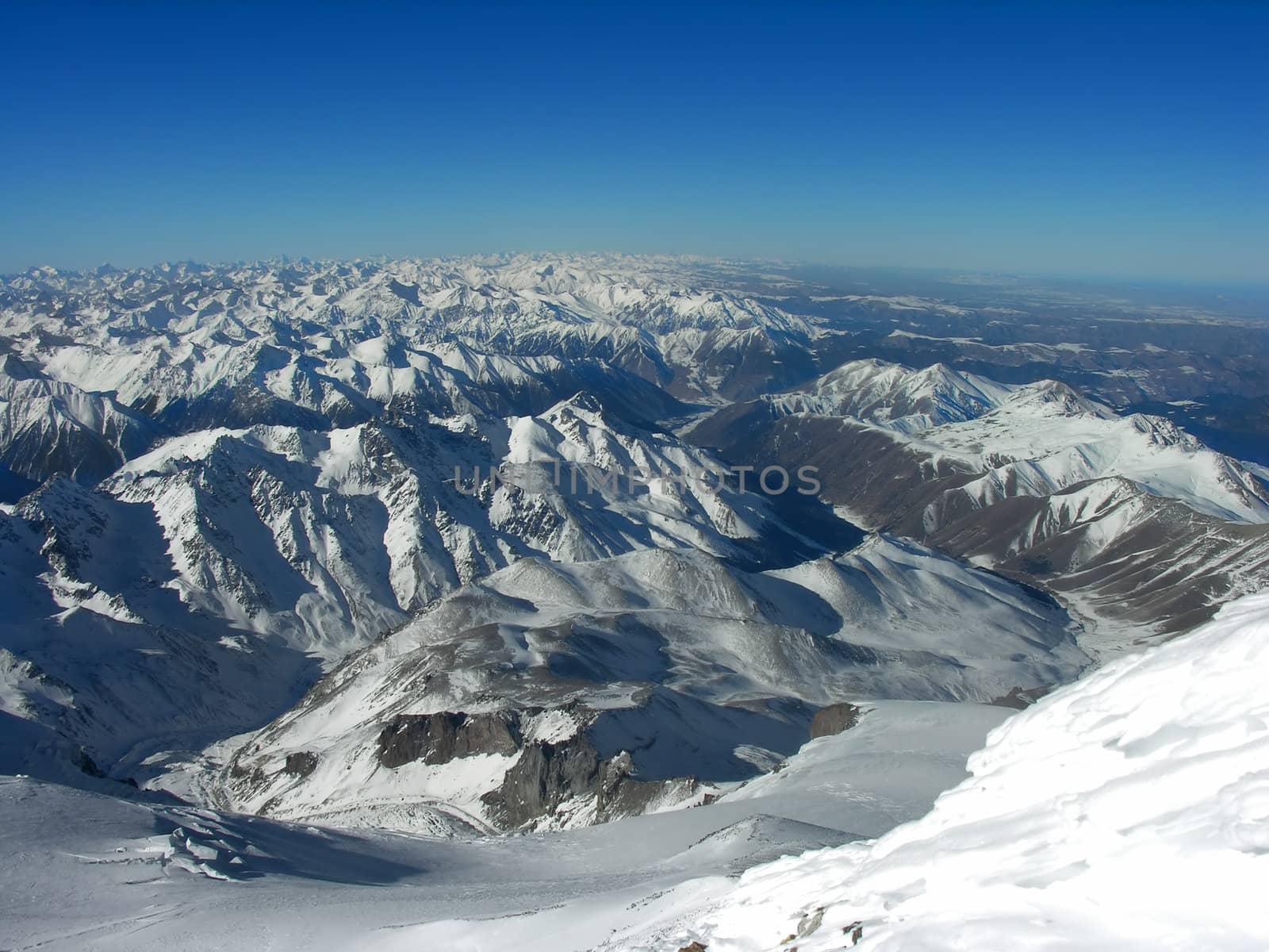  Snow-covered top of mountain on a background of the blue sky          