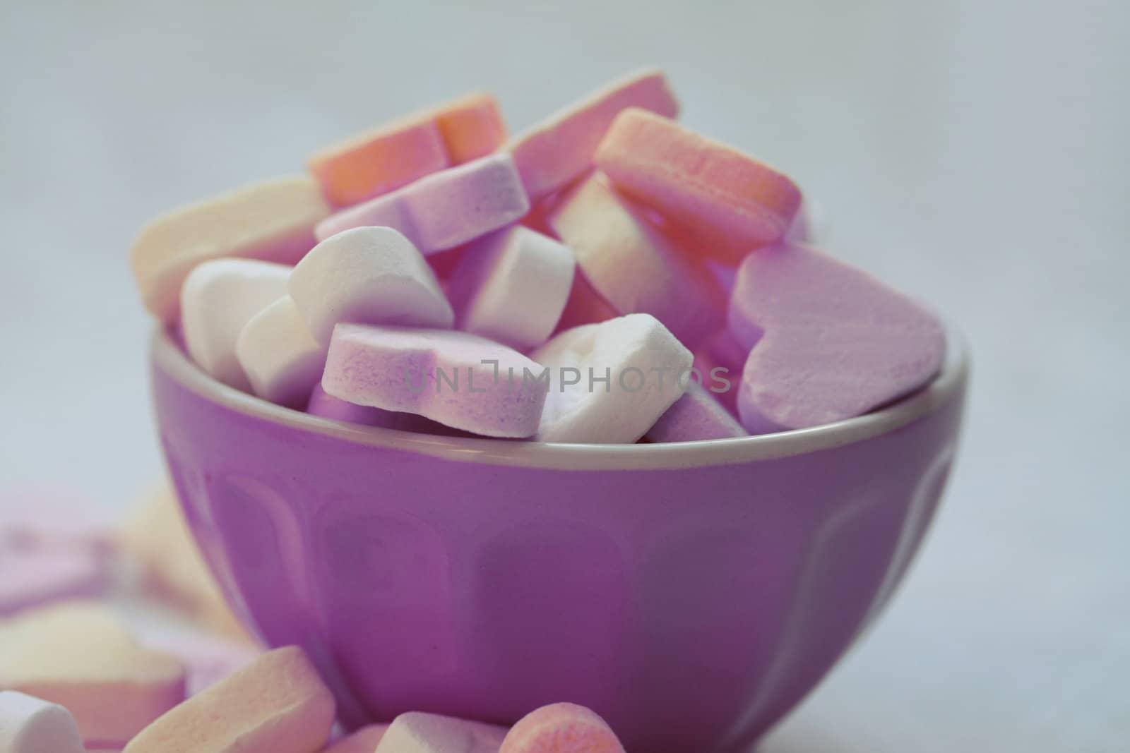 A bowl with candy hearts in sweet colors