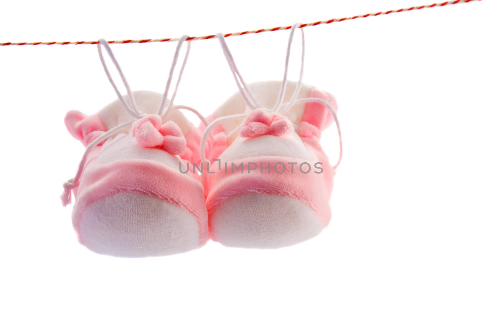 Pair of baby's slippers hanging on a rope. Including copy space.