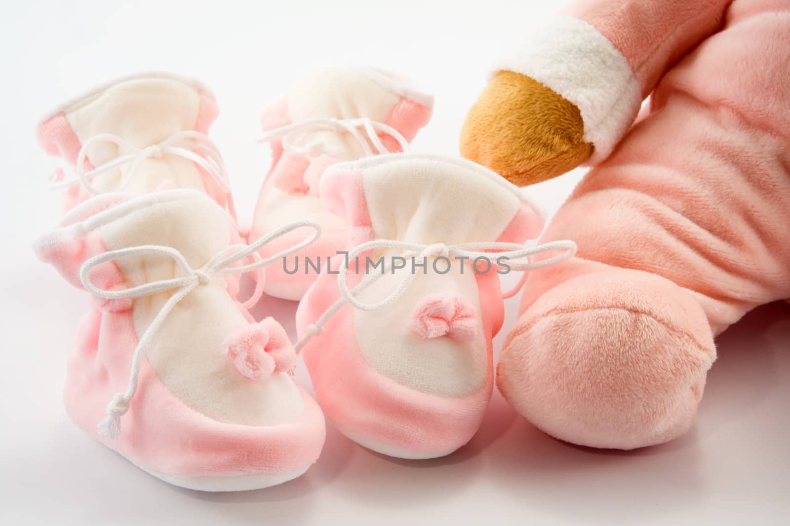 Two pairs of baby's slippers and teddy bear