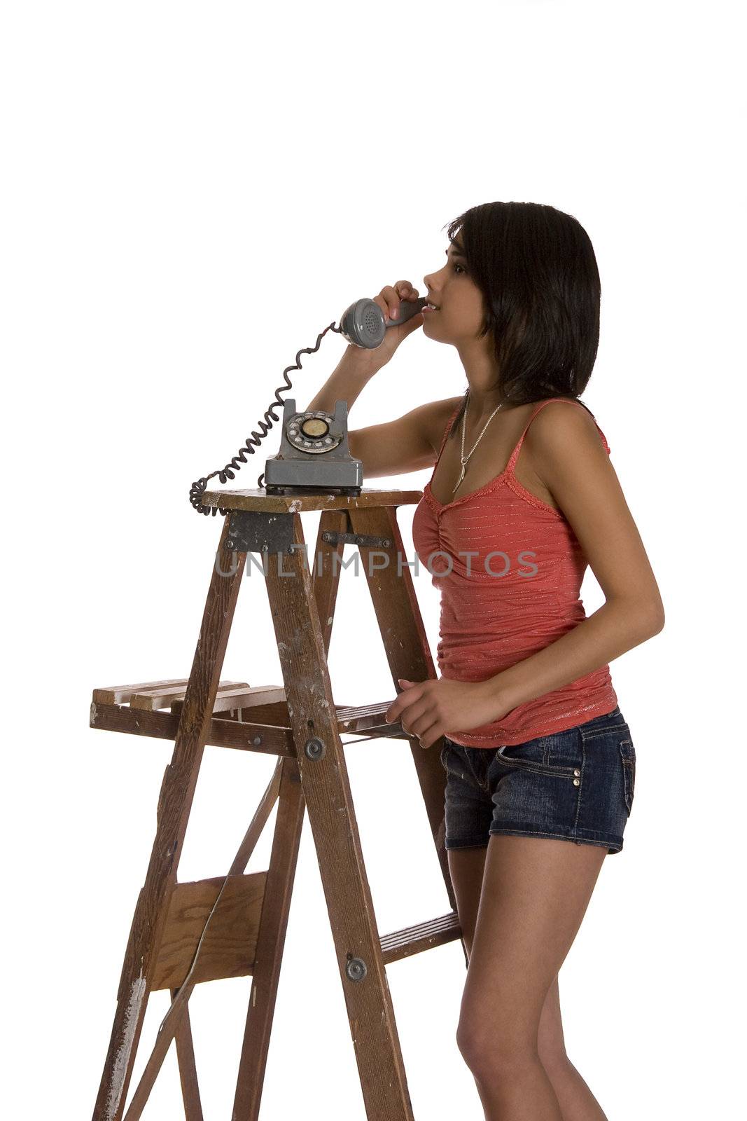 teenage girl standing on ladder talking on a old rotary phone