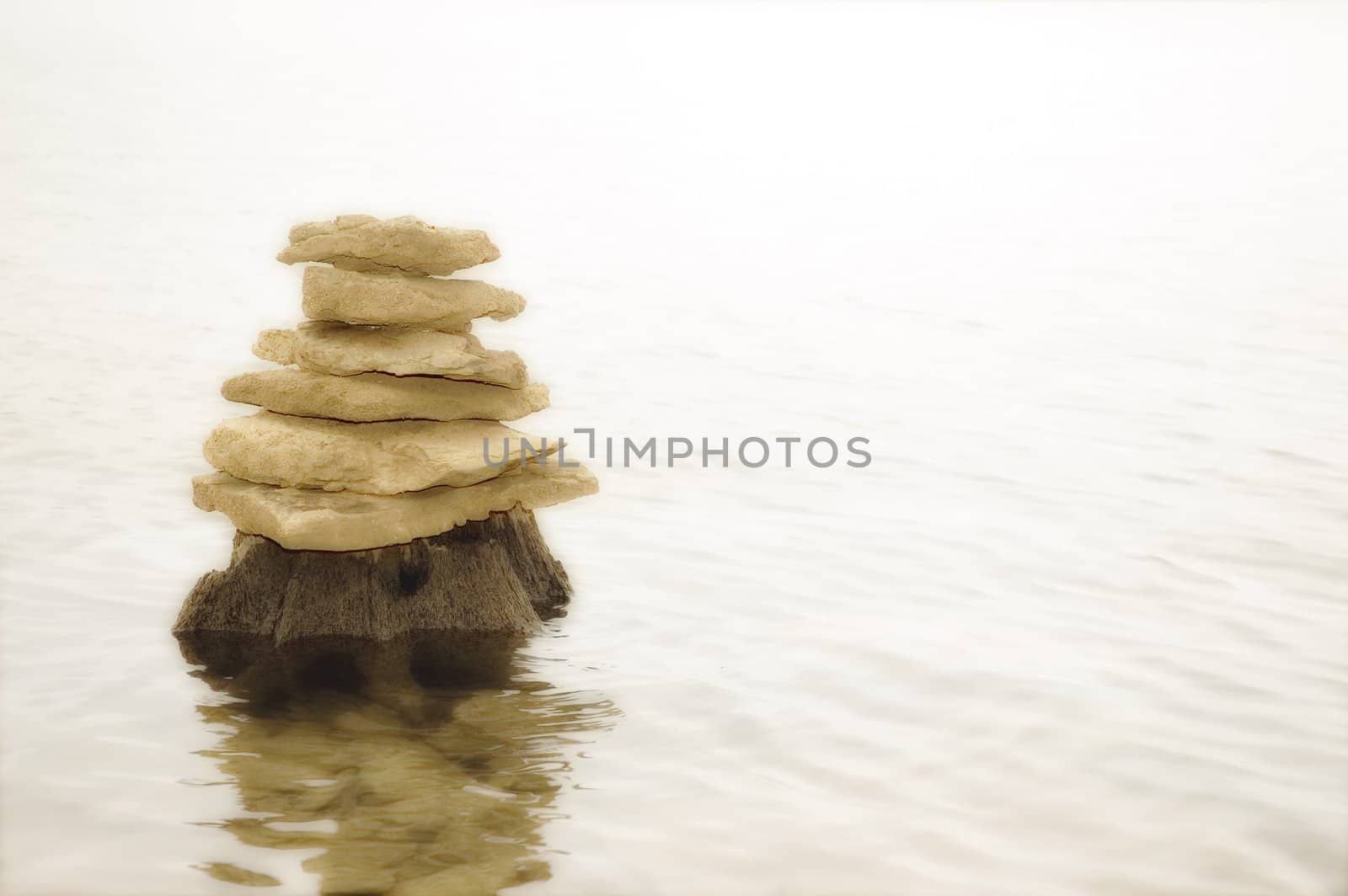 Rocks balancing on top of each other, picture fading to a white background