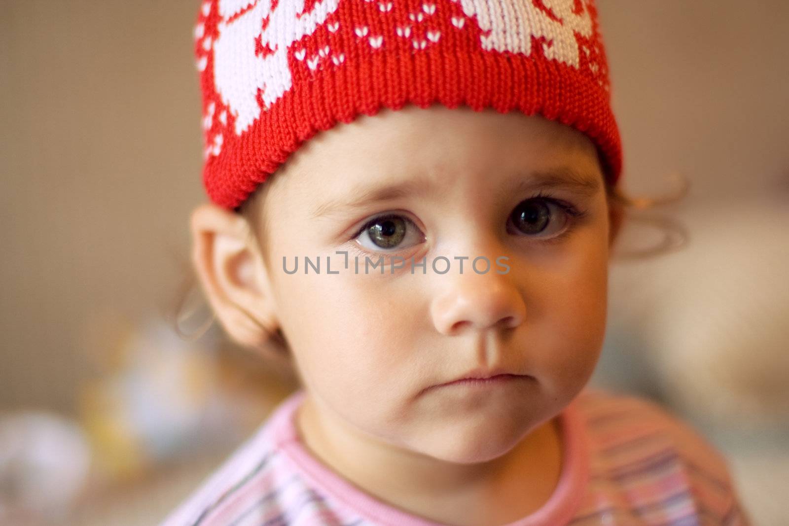 portrait of sad and sorrowful little girl in red hat