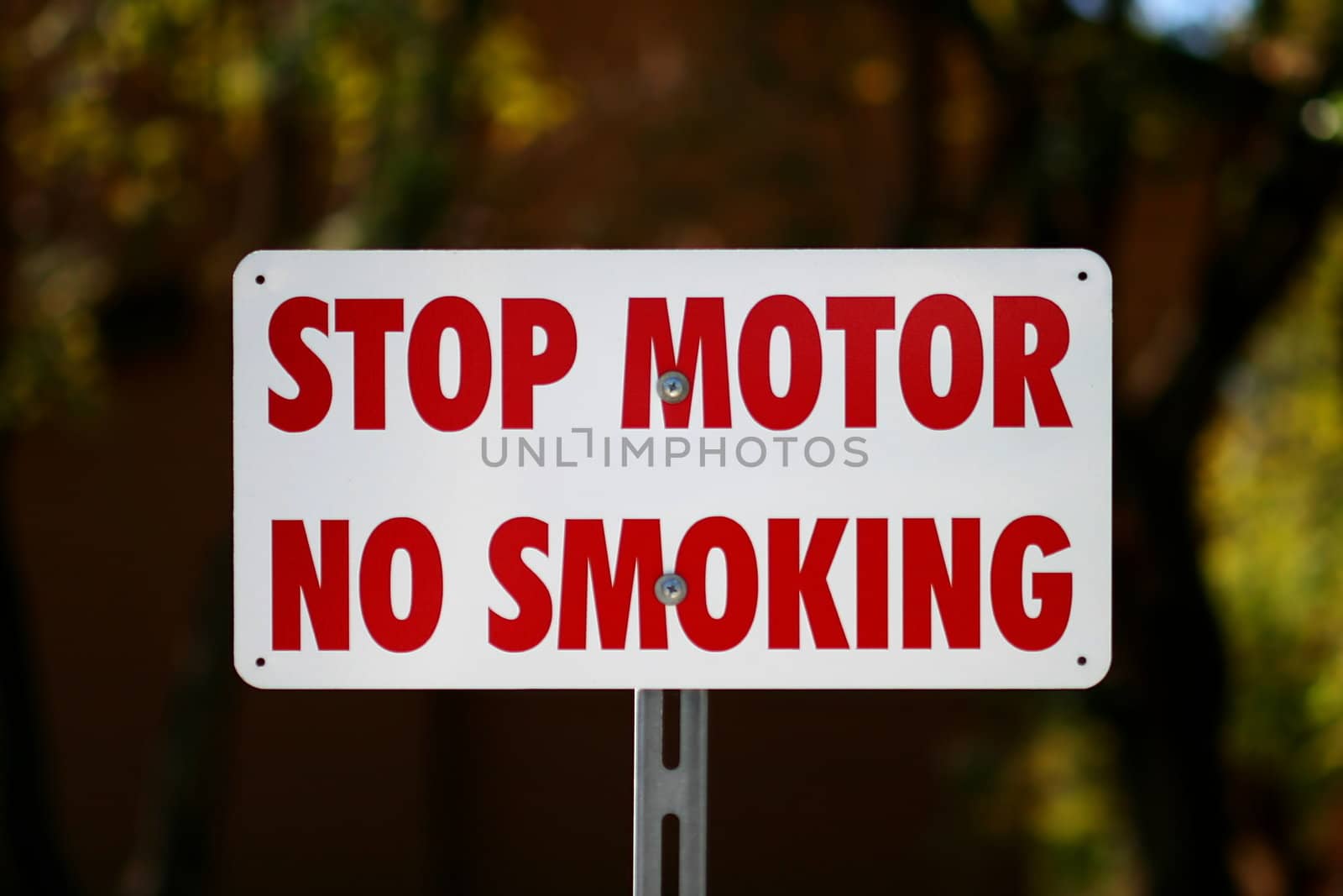 Whit sign with text Stop Motor No Smiking