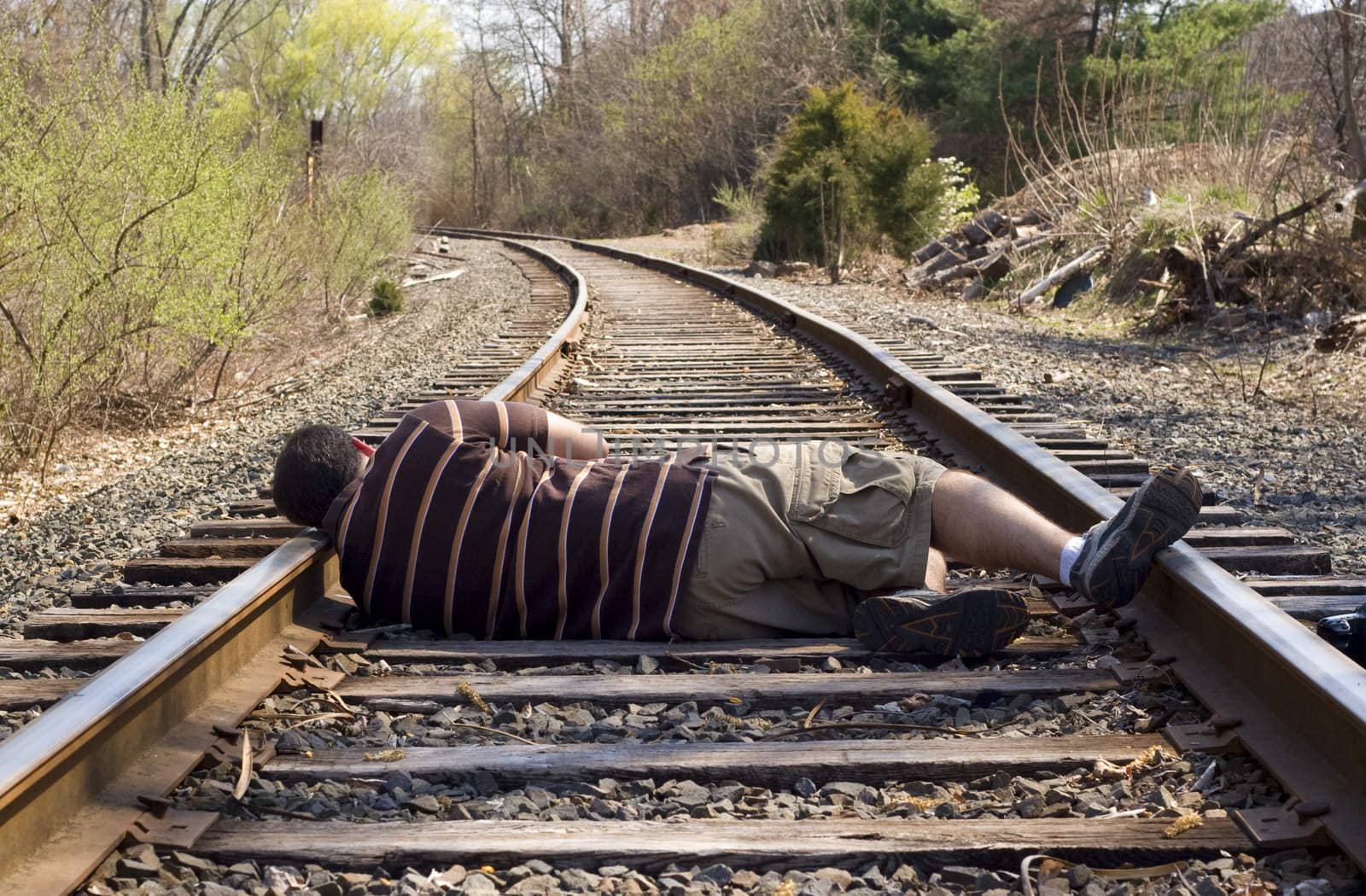 A man laying on the railroad tracks.  Not exactly the smartest thing to do.
