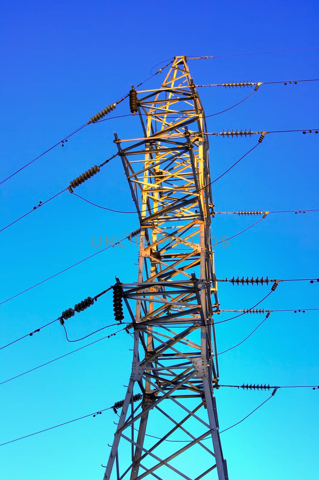 Electricity pylon against an intense blue sky by MIL