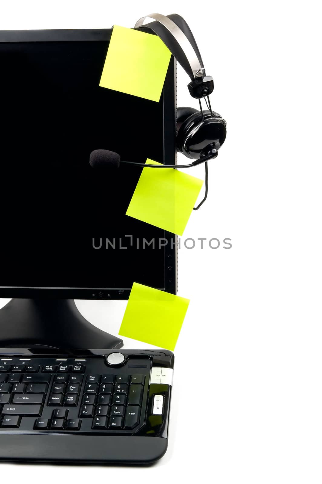 Computer with VOIP headset hanging on the screen, isolated on white background. Internet communications, VOIP (Voice Over Internet Protocol), call-center concepts. 