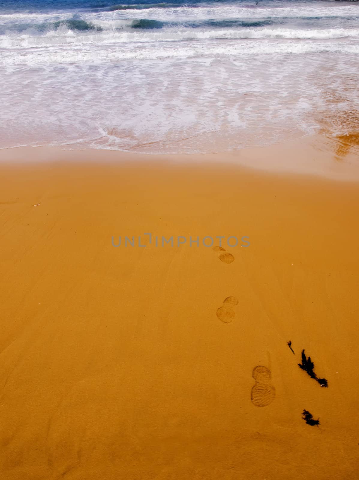 Footprints on a Mediterranean beach on the island of Malta in HDR