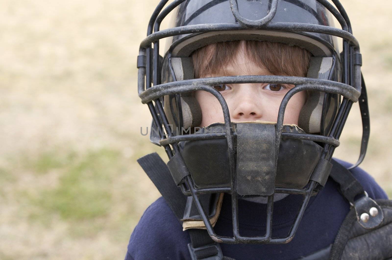 a young boy in baseball catchers mask