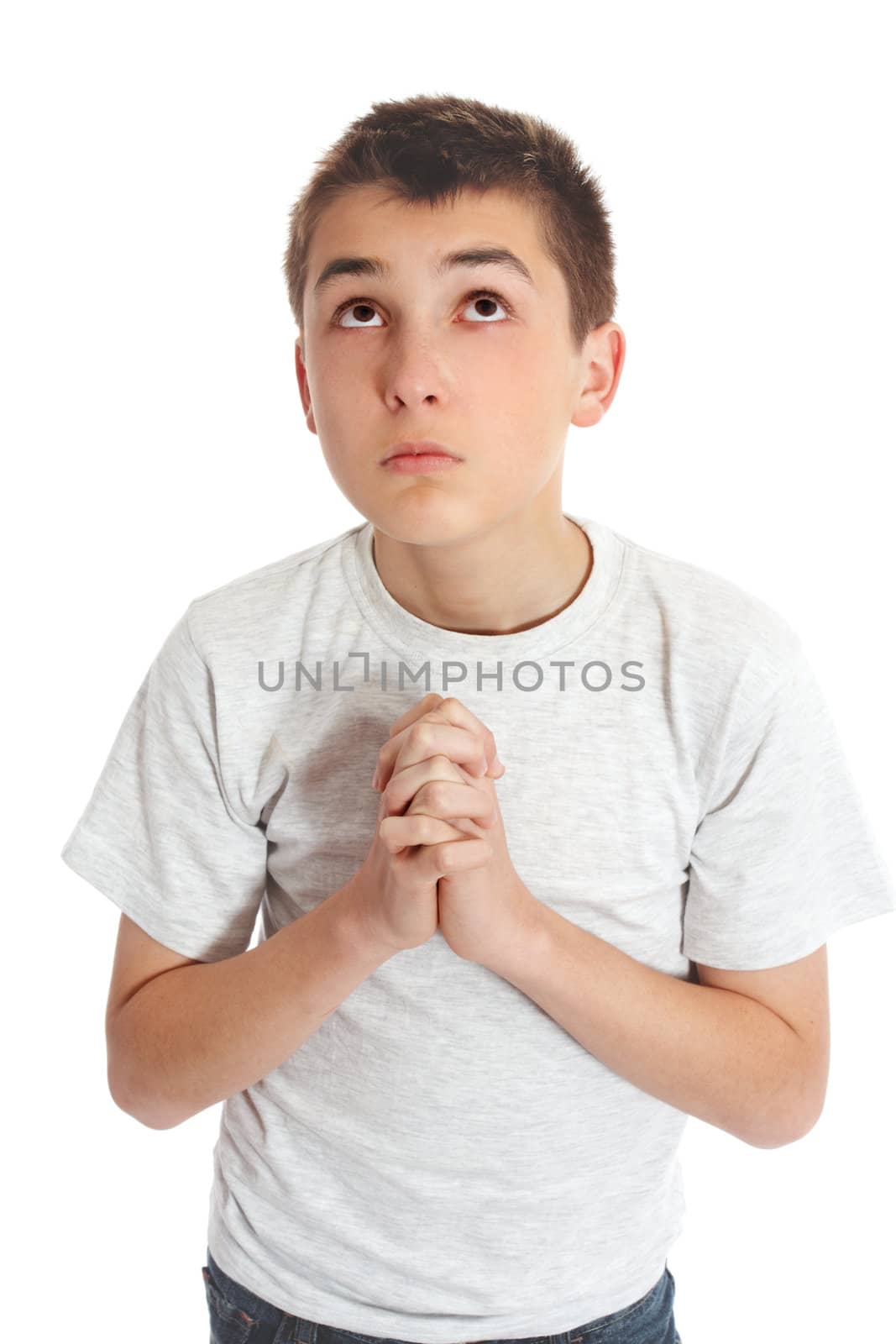 Boy with hands clasped in prayer looks to heaven God for answers