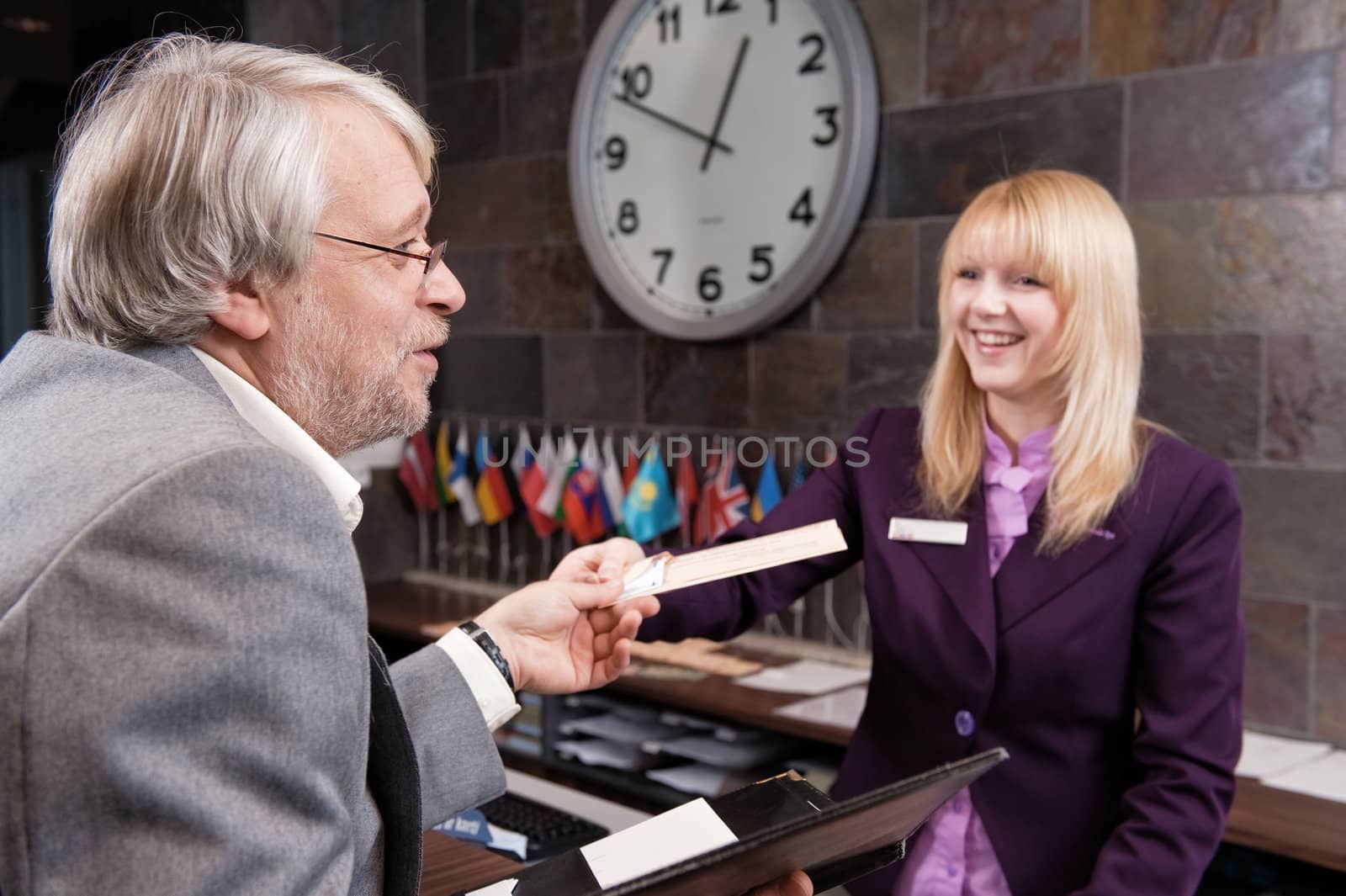 Businessman checking in at the reception desk 
