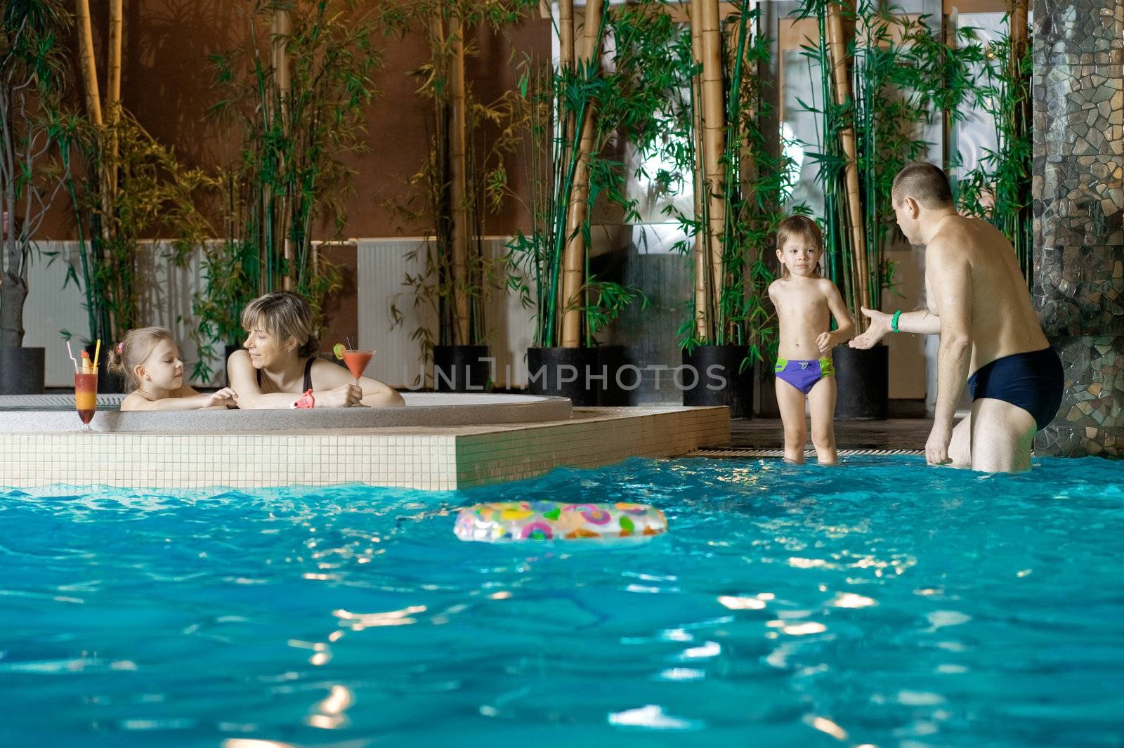 Happy attractive family relaxing by the pool