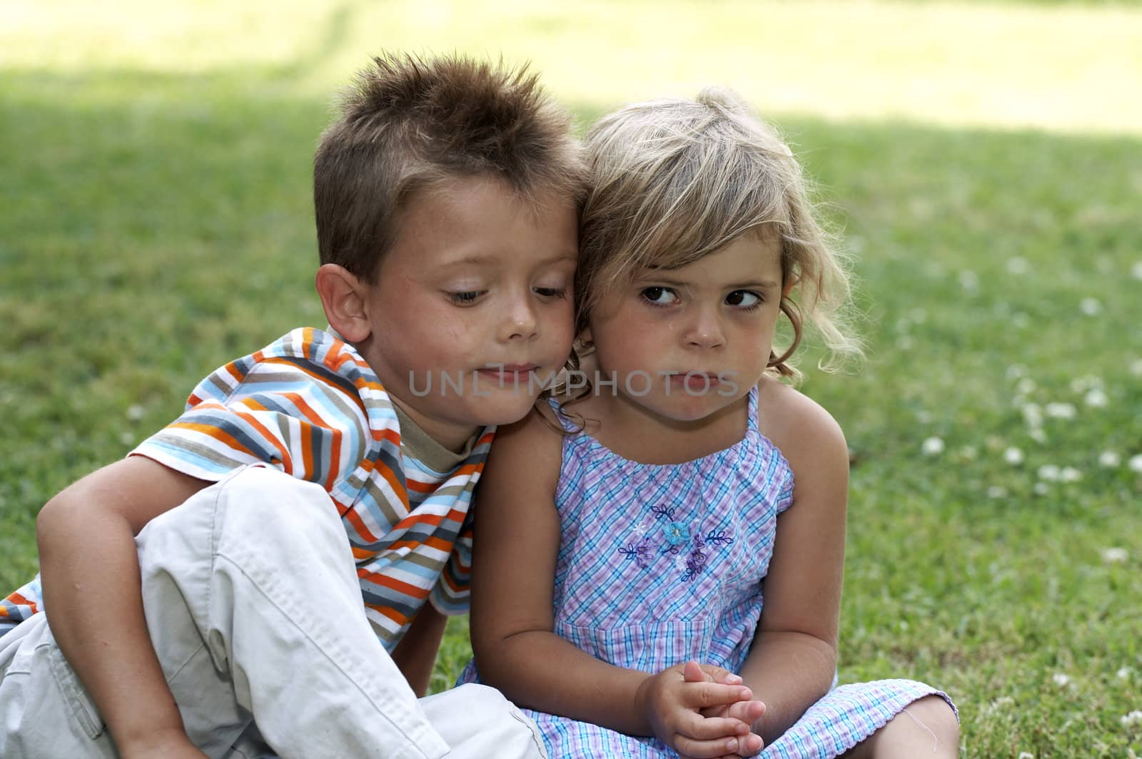 boy and girl sitting in the grass together