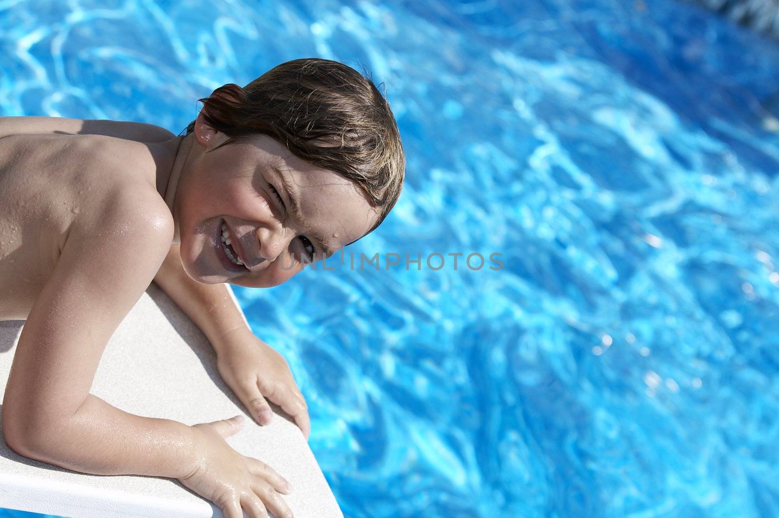 a boy looking into a pool from the diving board