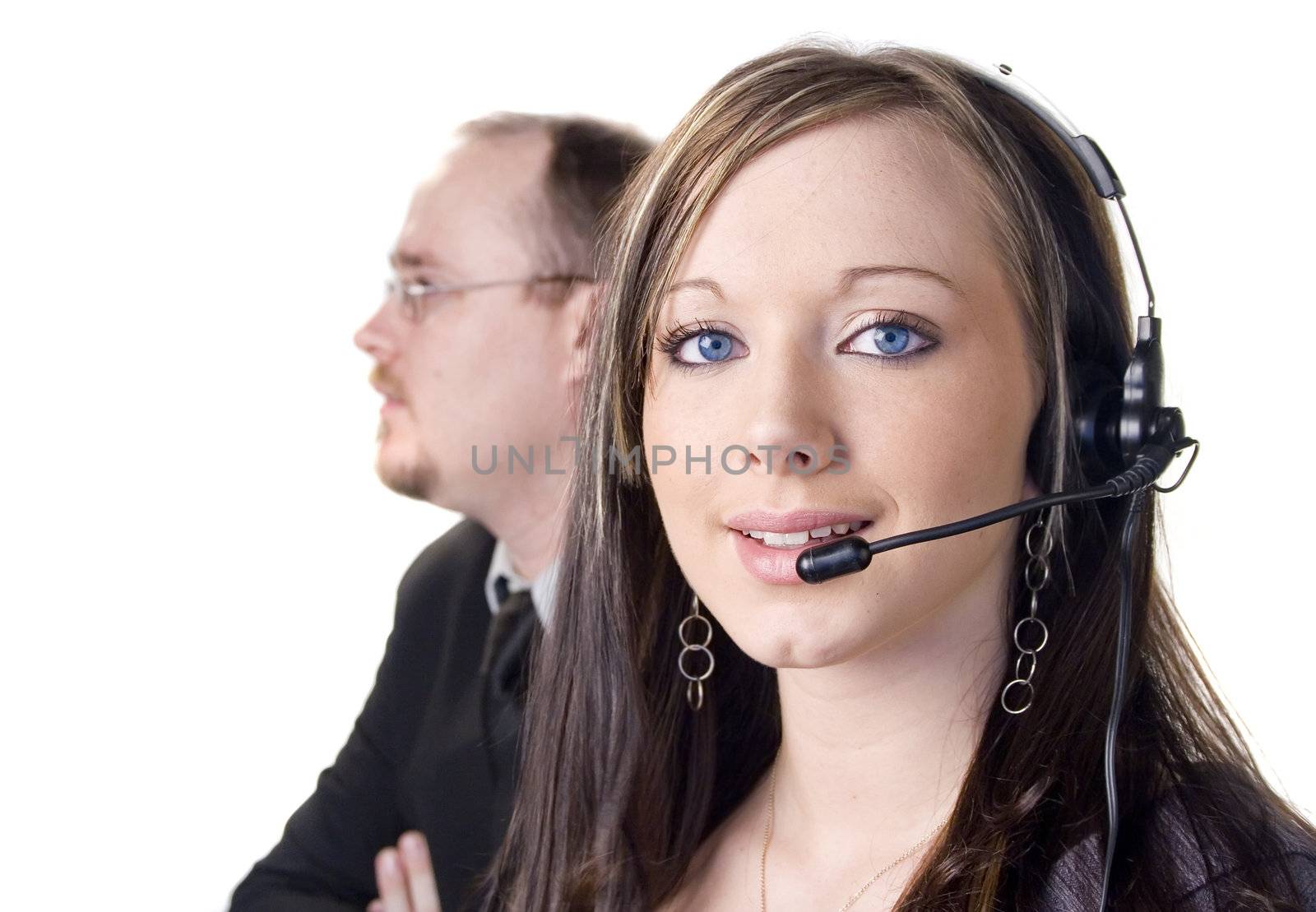 Young woman with headset and man in background on white