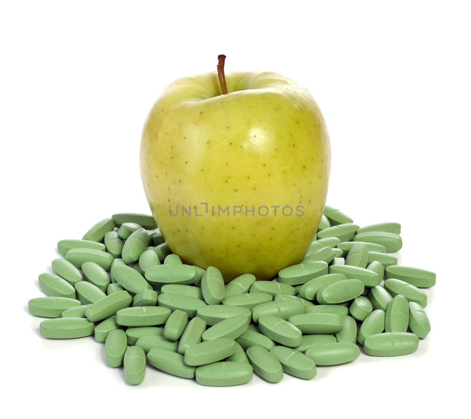 Concept image of an apple sitting on a bunch of vitamins to show that this fruit is full of nutrients