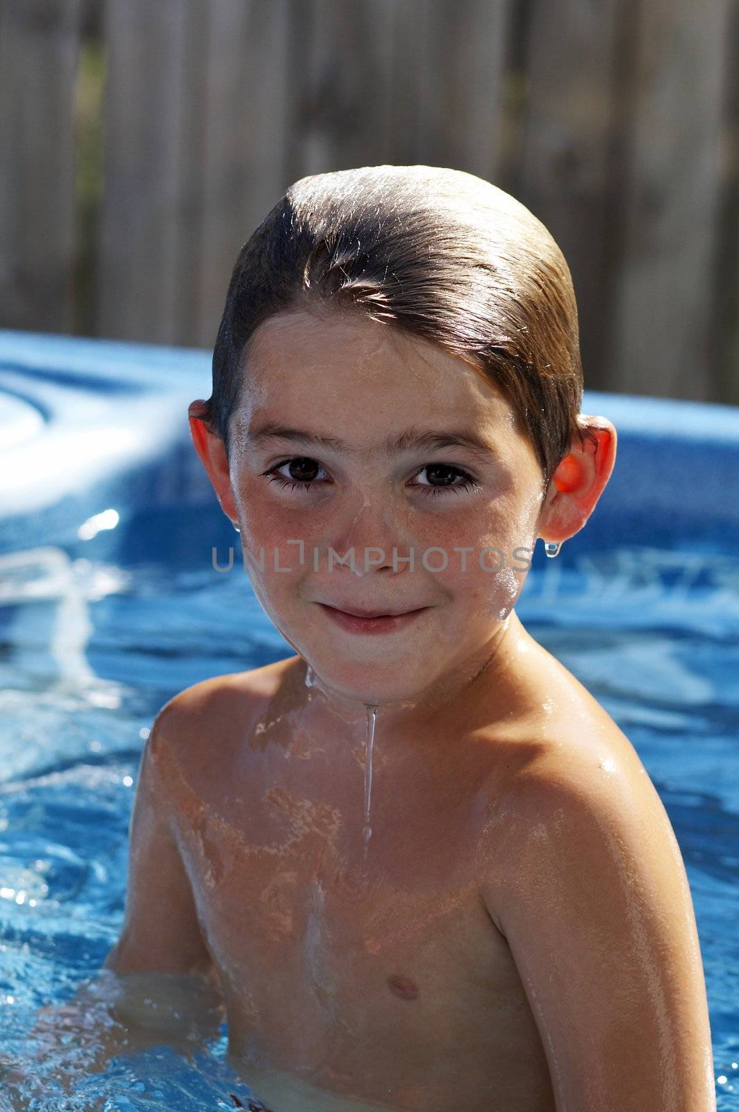 cute young boy in pool smiling