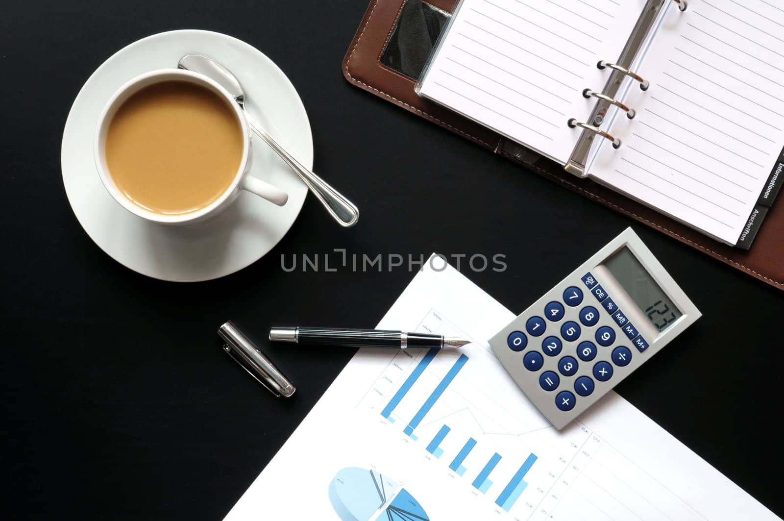 coffee pen phone and paper on desk in office