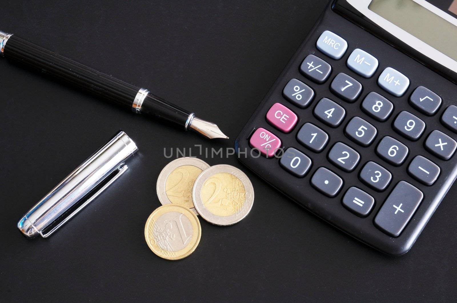 save money concept with calculator and euro money coins on black