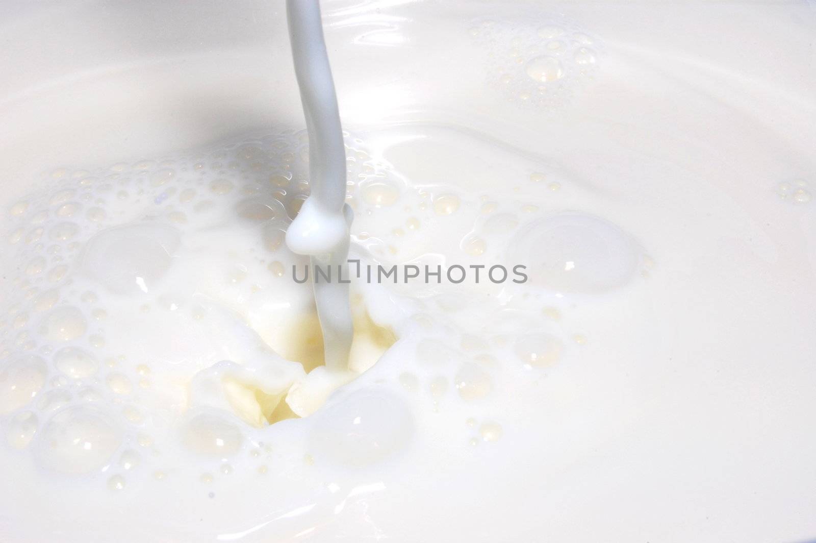milk splashing into fresh milk with drops