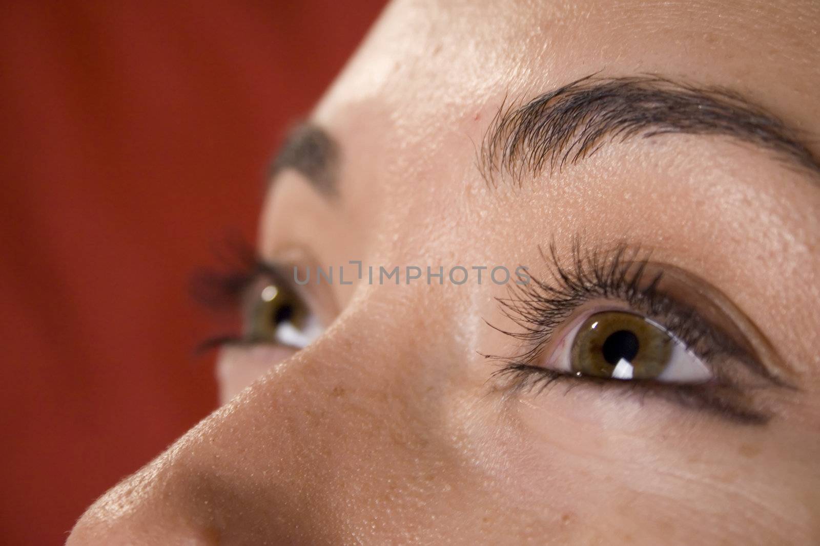Close up of womans eyes on red background