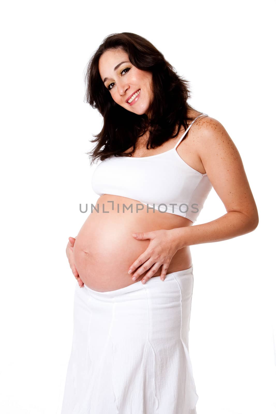 Beautiful happy smiling pregnant woman dressed in white holding her belly, isolated