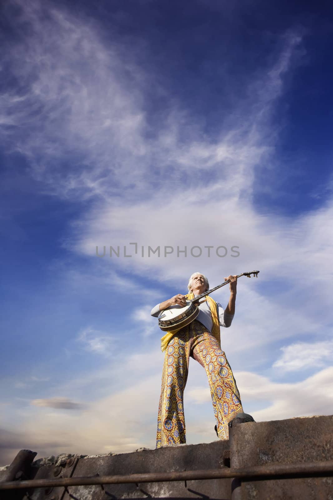 Banjo Player with groovy clothes against a wide sky