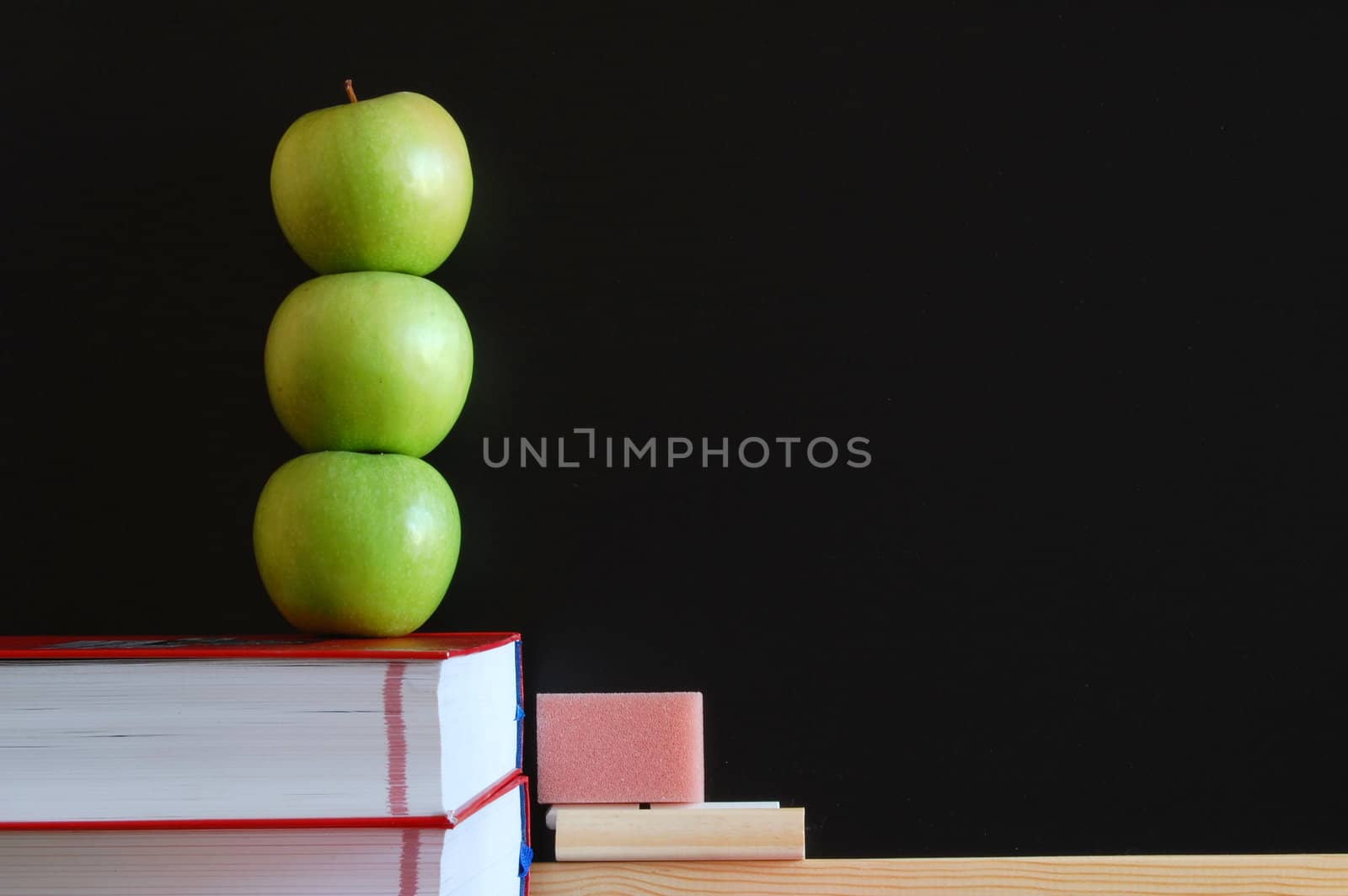 blank blackboard with apple and books and text space