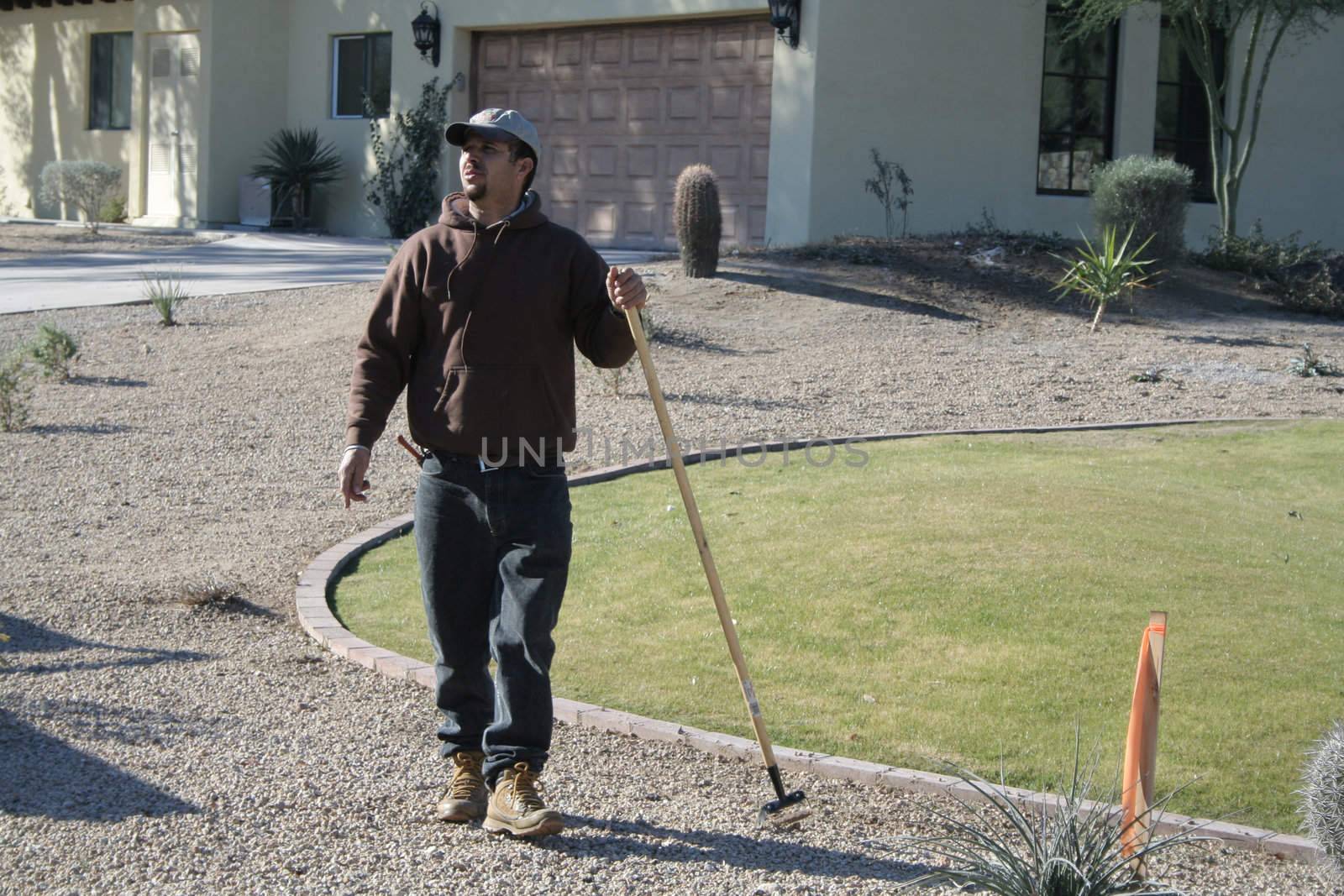 Man doing maintenance of landscaping at upscale home