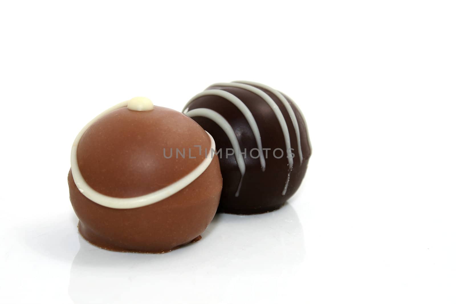 two chocolate truffles on white background