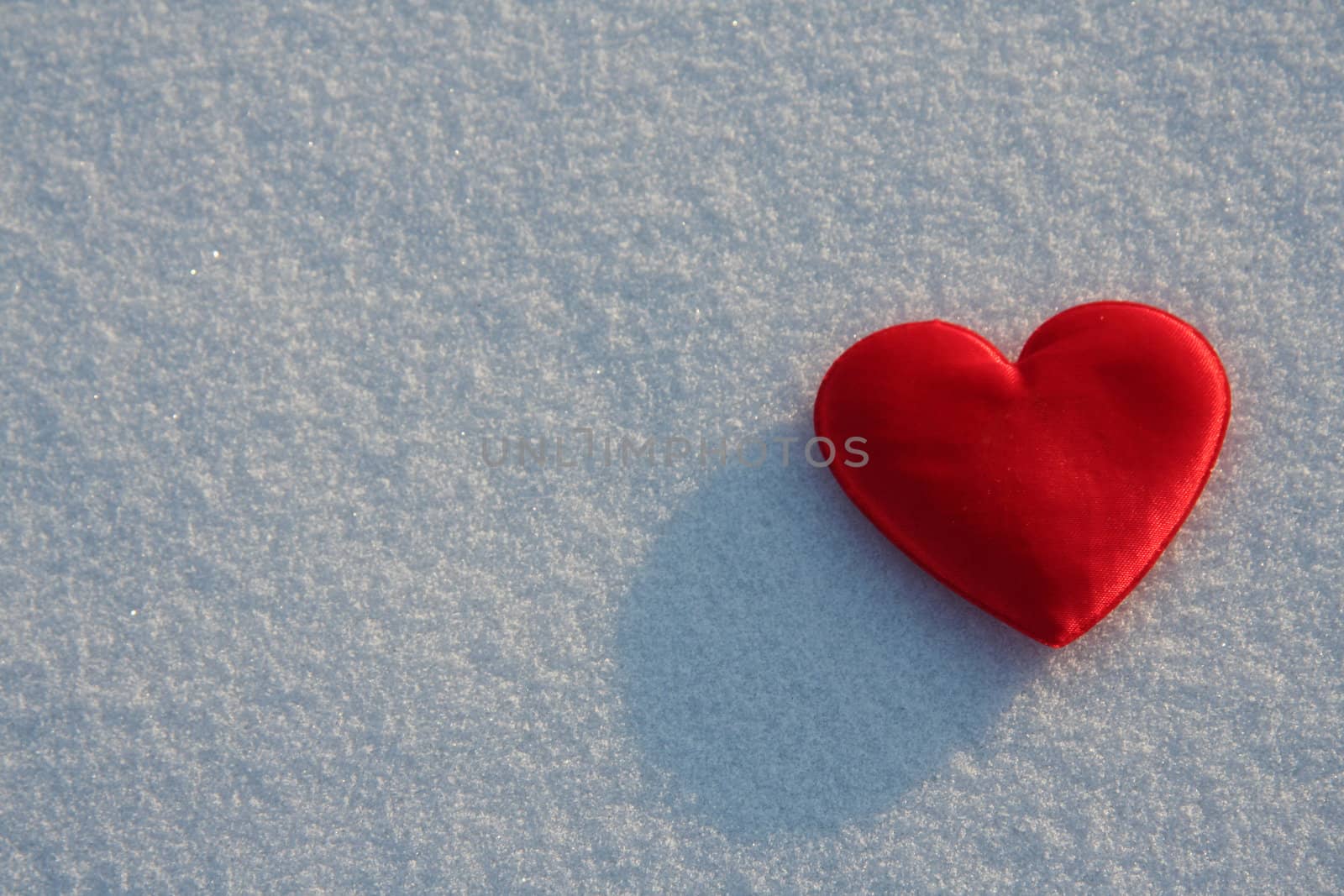 Red silk heart on the snow